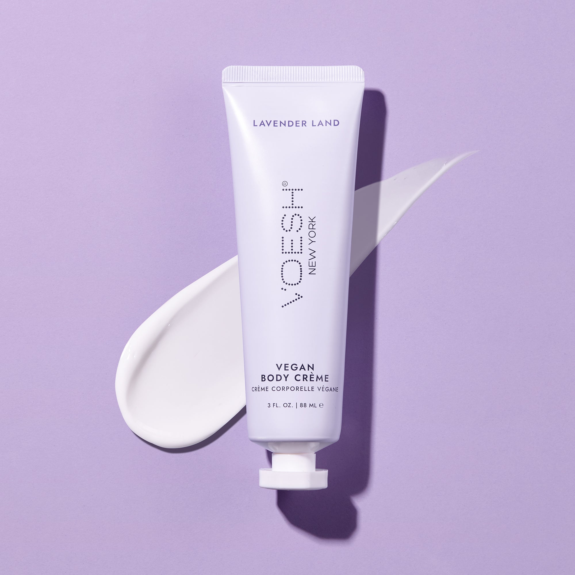 Vegan Body Crème Lavender Land pictured on top of the lotion’s texture on a purple background.